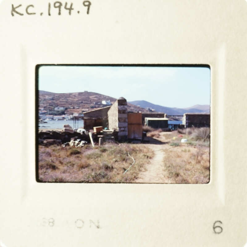 A photo of an outdoor scene with a dirt road leading to a small building, possibly a shack, and a clear sky above.