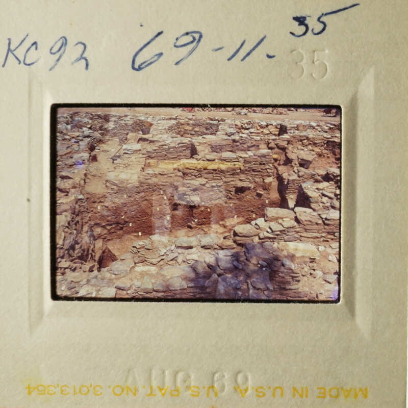 This is a photograph of an old slide featuring a rocky structure, possibly ruins or a stone wall.