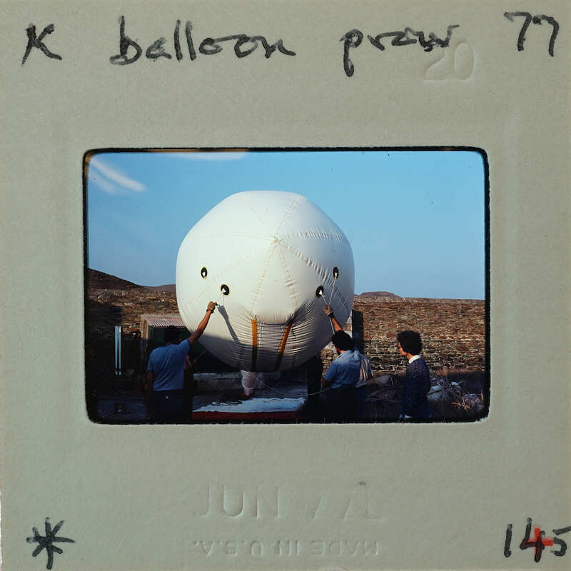 A group of people working on an unusual large balloon.