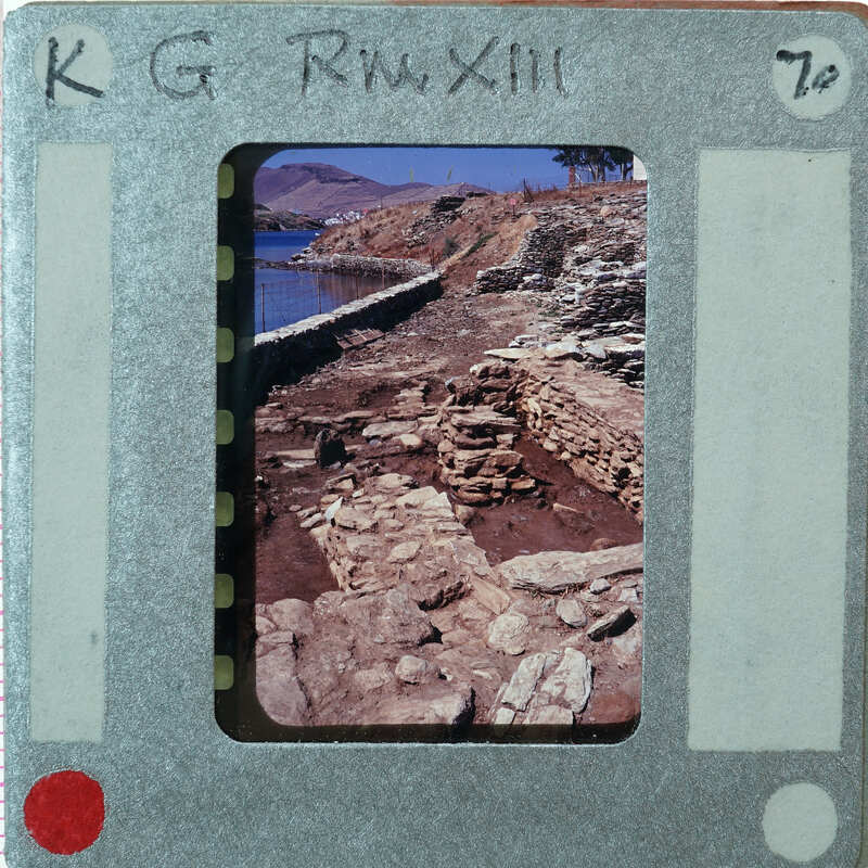 A photograph of a stone-paved path with the sea and mountains in the background, displayed on a film strip.