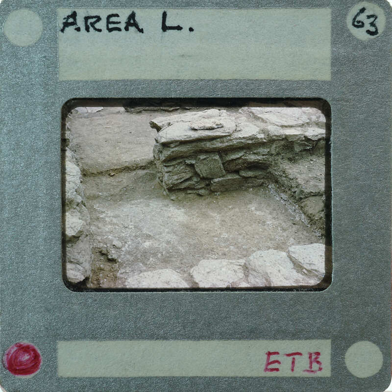 The image shows a photograph of an archaeological site with stone ruins, placed within a mockup of a Polaroid-style photo frame.