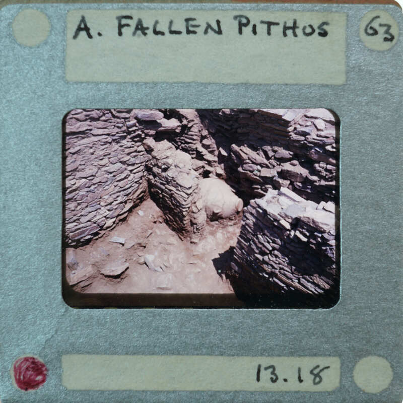 A photograph of a fallen pithos, which is an ancient Greek storage jar, displayed on a card with a description and date stamp.