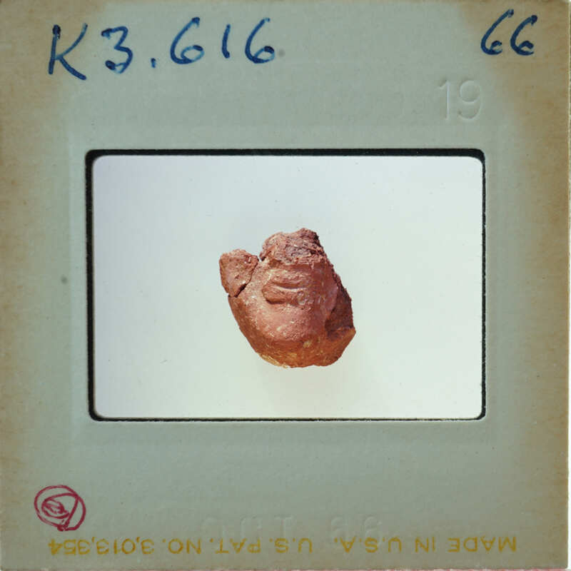 A photograph of a clay face mask on display.