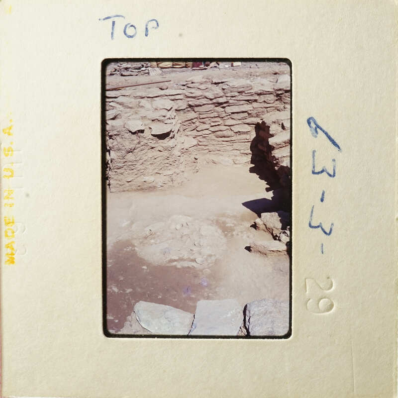 This is an old photograph showing ruins with stone walls and foundations, possibly from an ancient civilization.