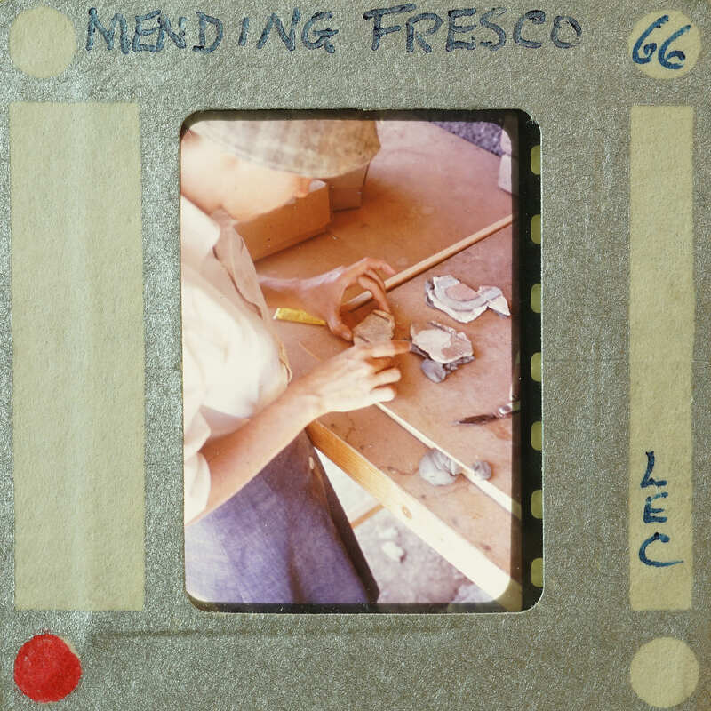 A person working on a craft project with various materials and tools around them.