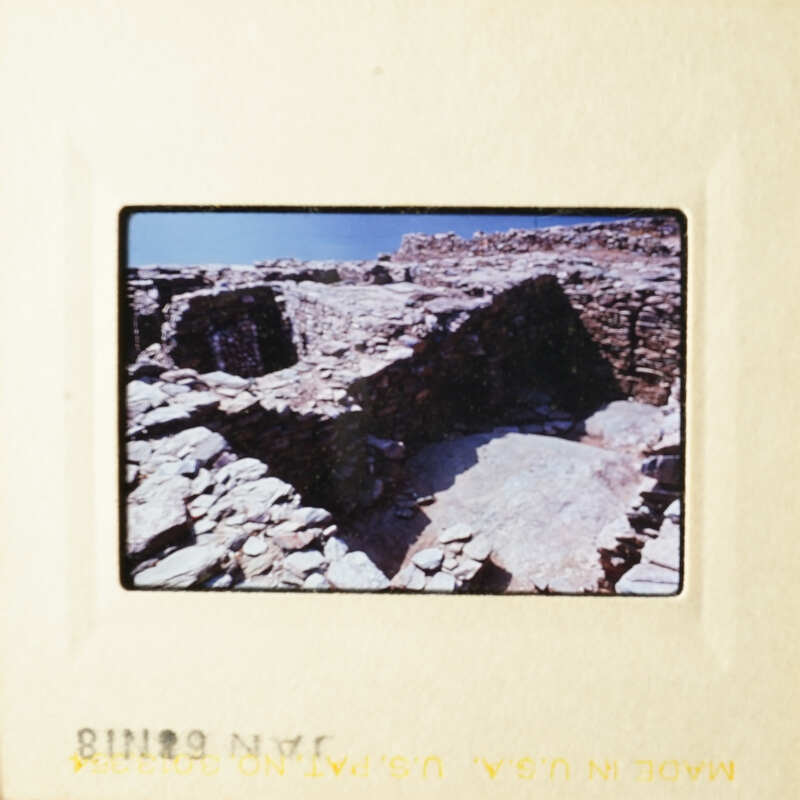 The photo shows an ancient stone structure, possibly a temple or shrine, with a clear sky above.