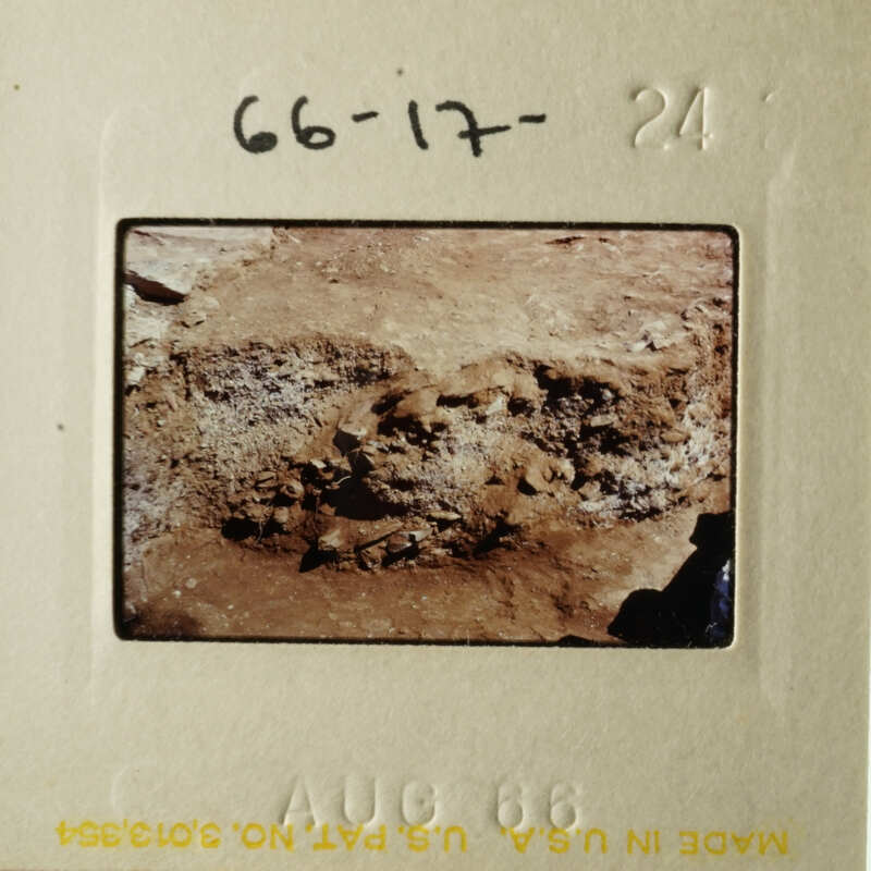 The photo shows an ancient archaeological site with stone ruins and dirt.