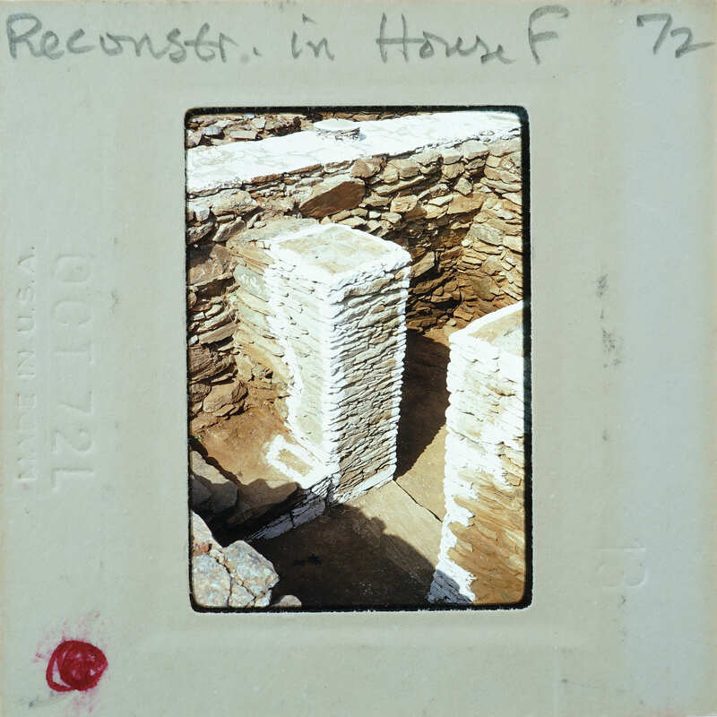 Old photo of a stone structure with a dark interior, possibly a cave or ruins.
