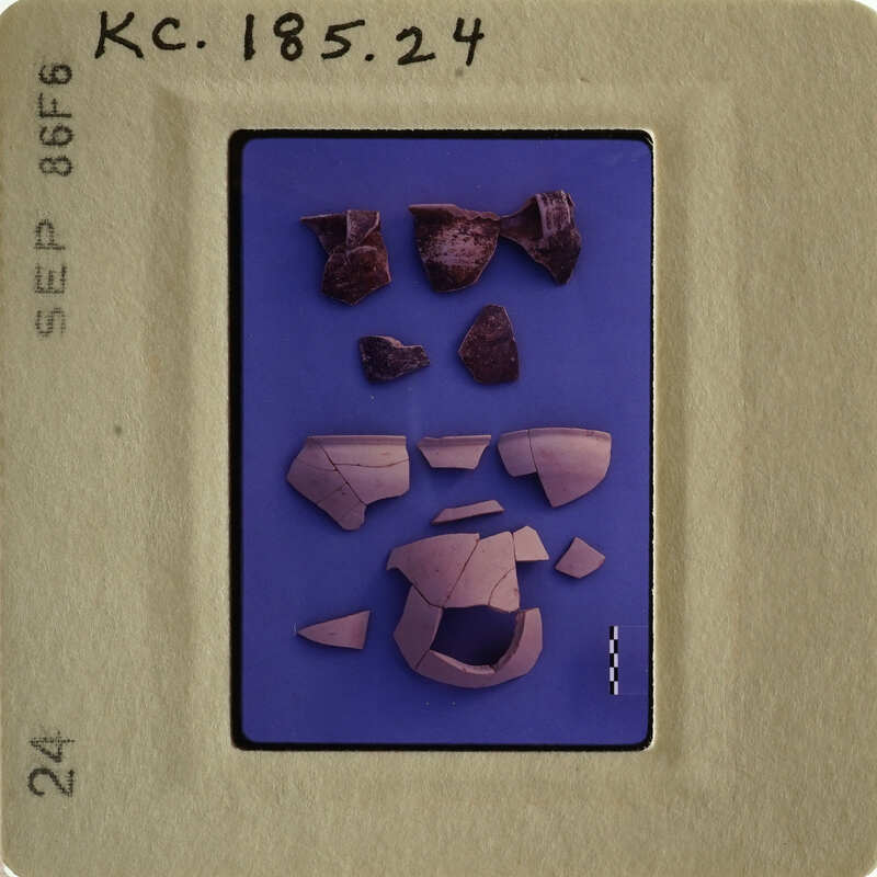 The image shows fragments of ancient pottery on a blue background, with some pieces overlapping and others scattered around.