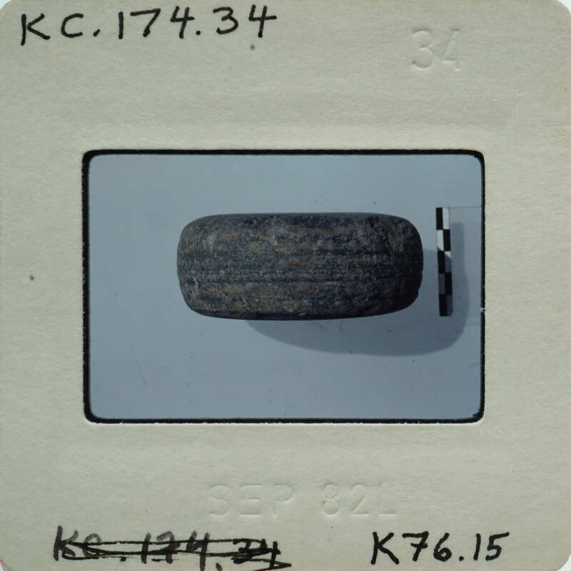 A photograph of a small stone object on a white surface.