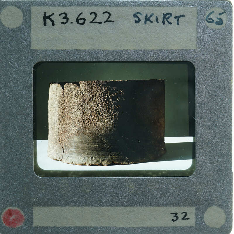 Broken base of terracotta figurine skirt.