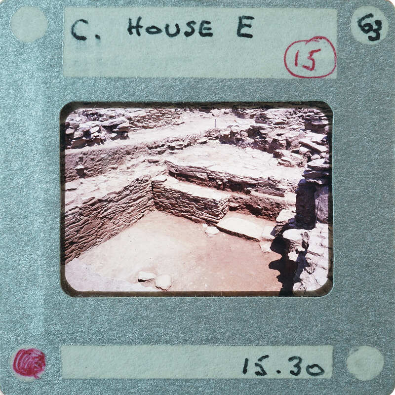 Excavated stone walls with a doorway on right.