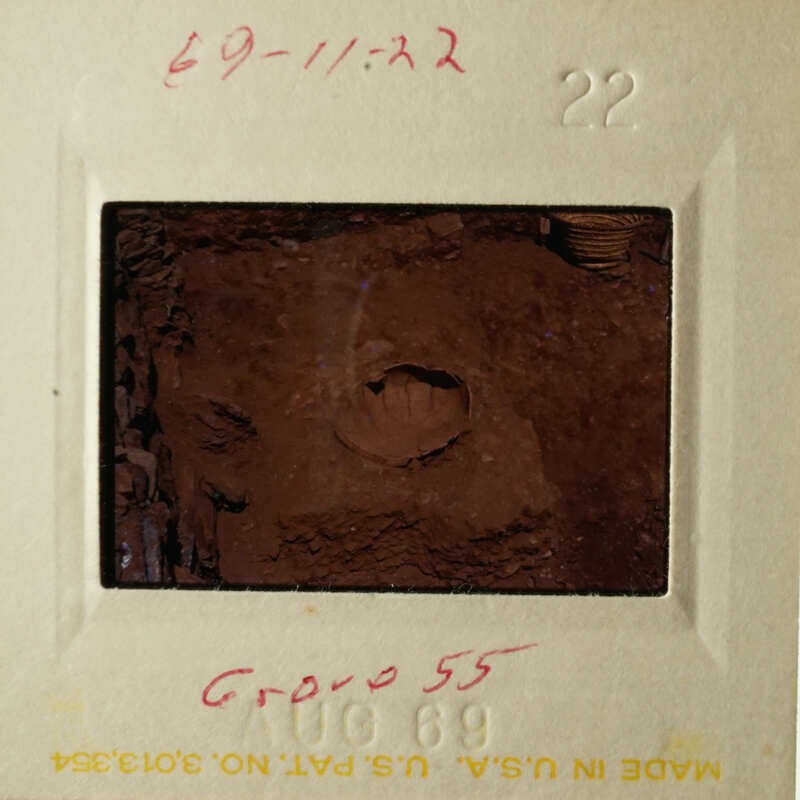 The photograph shows an old slide with a brownish-red substance, possibly soil or mud, and some writing on it.