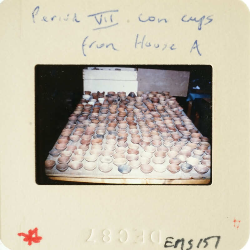 Photograph of clay pots drying on racks.