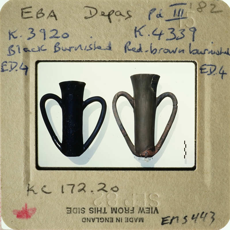 Two black vases with handles, one intact and one broken, displayed against a white background.
