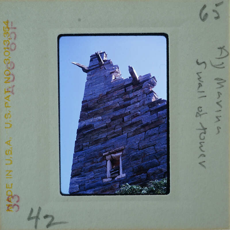An old, stone tower with a pointed roof and windows.