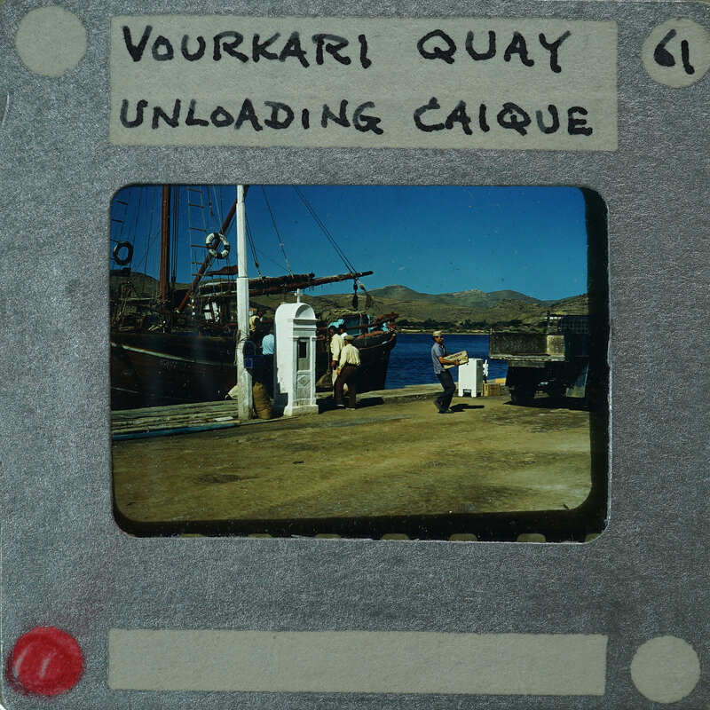 Old photograph of a dock with boats and people, labeled "YOURKI QUIAY UNLOADING CAIQUE".