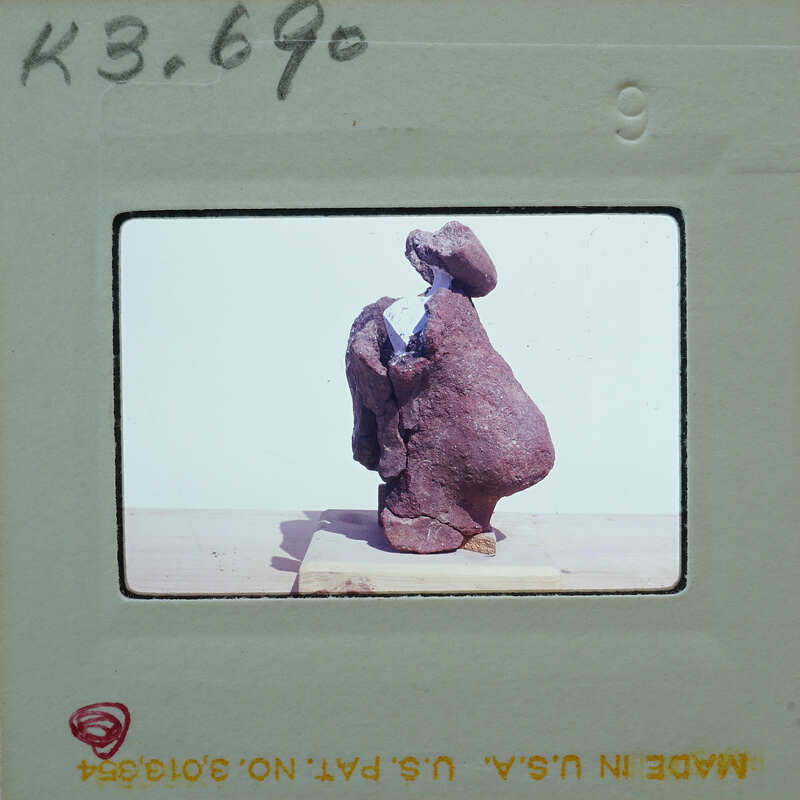 A photograph of a sculpture with a person's head and body, possibly made from clay or stone, on display.