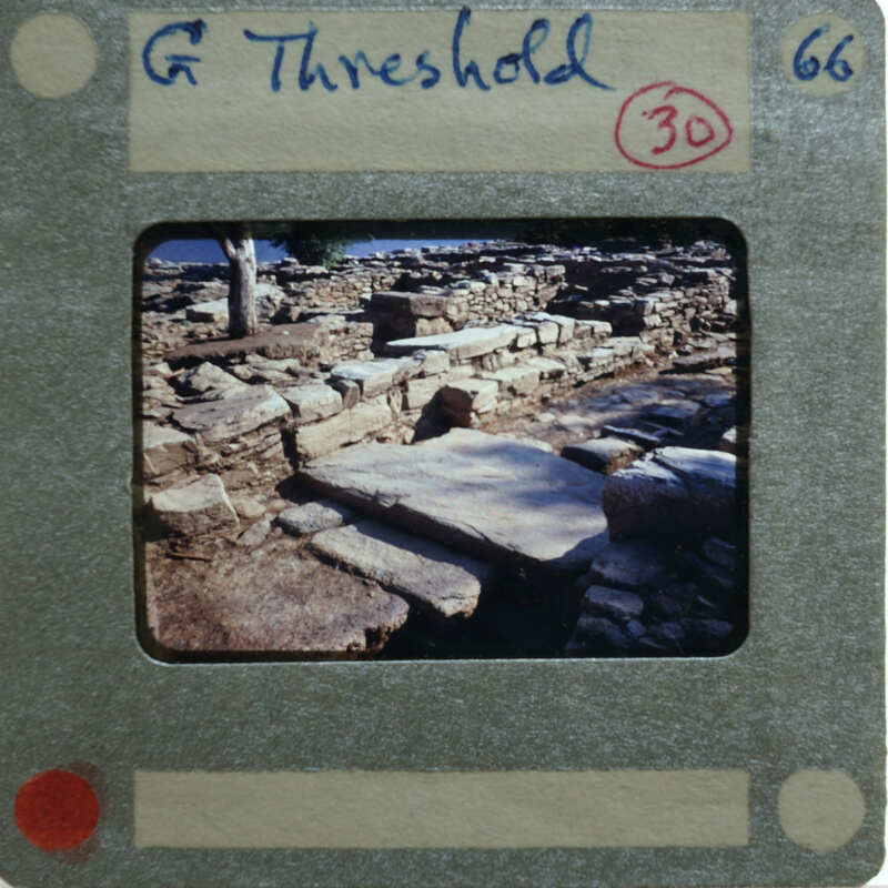 A photo of a stone ruins with a film strip label on it.