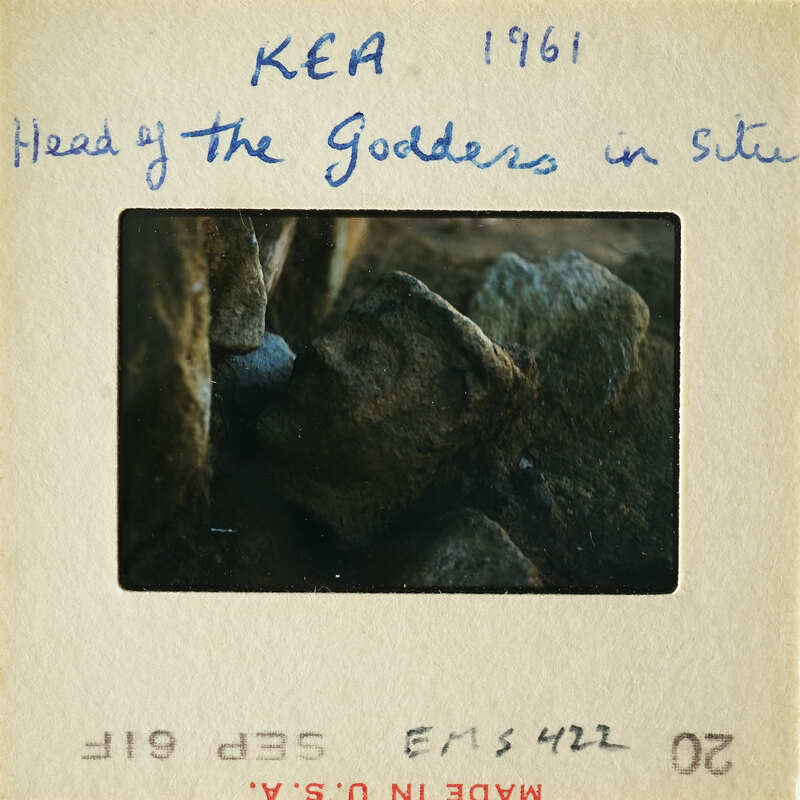 This is an antique photograph of an ancient artifact, possibly a sculpture or carving, set against a rocky background.