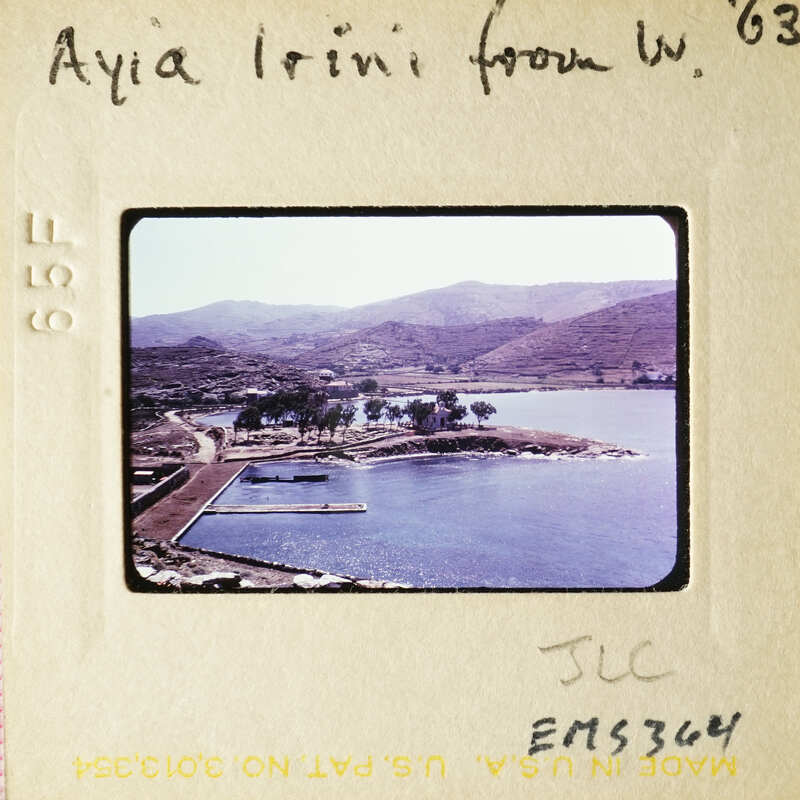 A photograph showing a scenic view with water, mountains, and trees.