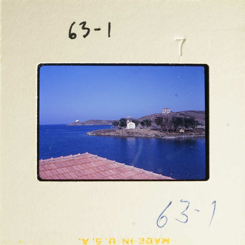 View of a coastal town with water and buildings under a blue sky.