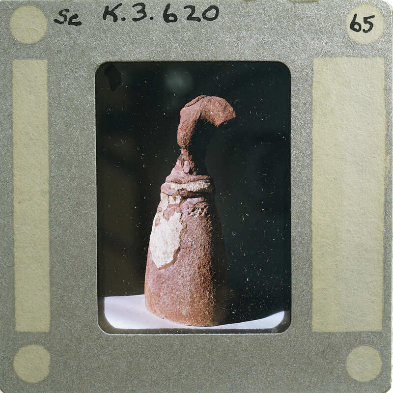 Terracotta figurine from side.