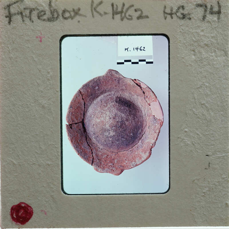 Circular ceramic fragment from top showing depression in center and repairs, identified as a firebox K.1462.