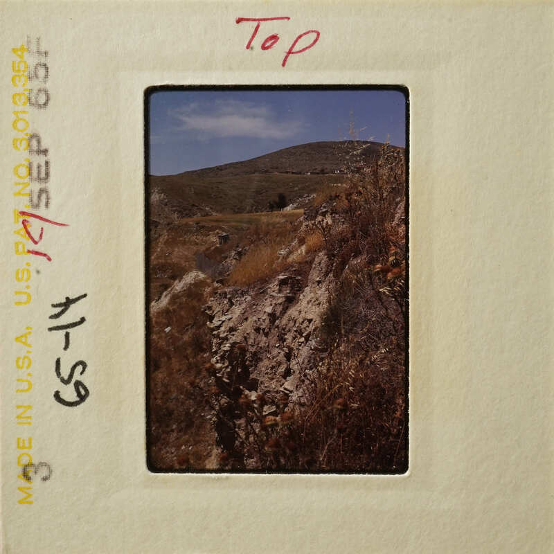 Mountains and rocks with blue sky background, captured on an old photograph.