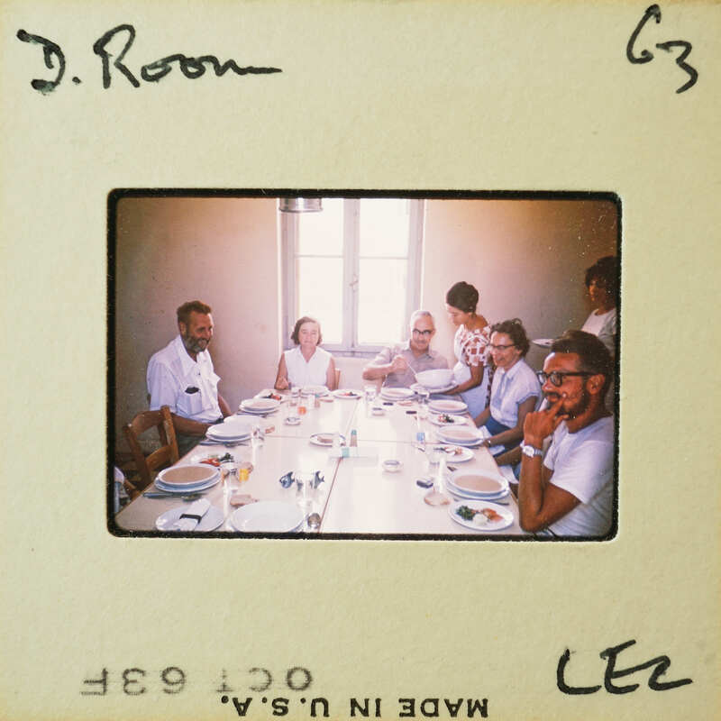 A group of people sitting at a table with plates and drinks, likely posing for the photo.