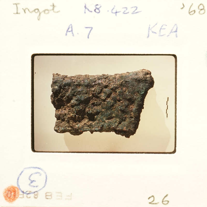 Photograph of an object with a rusted surface, possibly metal, on a white background.