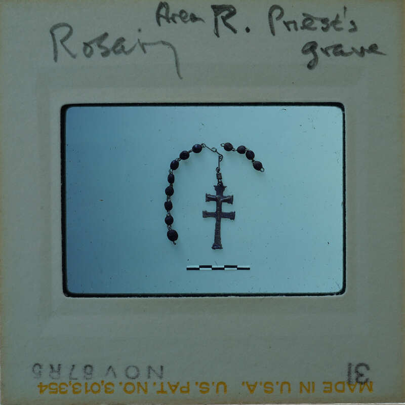 A black and white photograph of a rosary with a cross