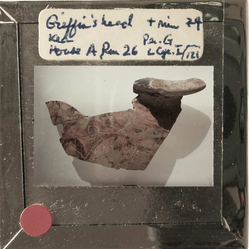 A photograph of a broken clay pot with visible damage and cracks, displayed on a white background.