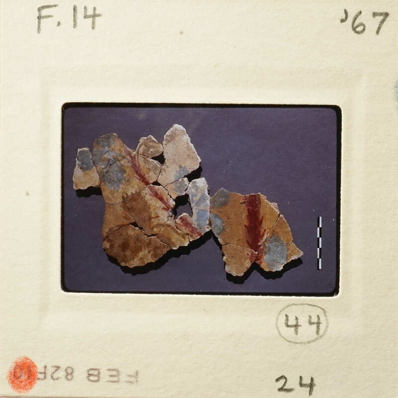 Old photograph of an artifact with blue and red markings on a white background.