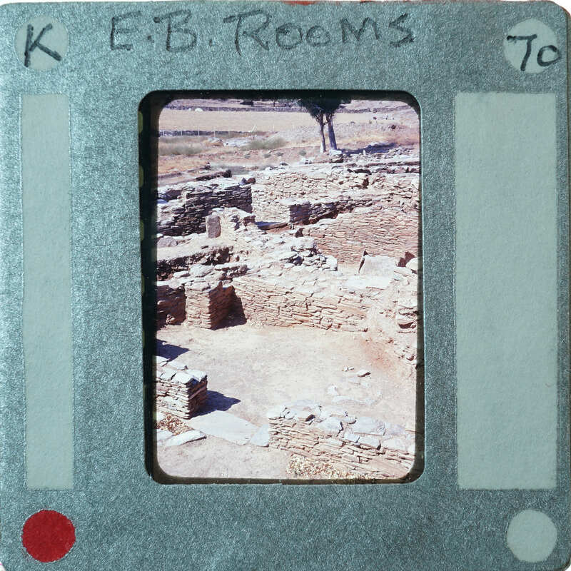 Excavated stone walls in various directions forming rooms with doorway in foreground.