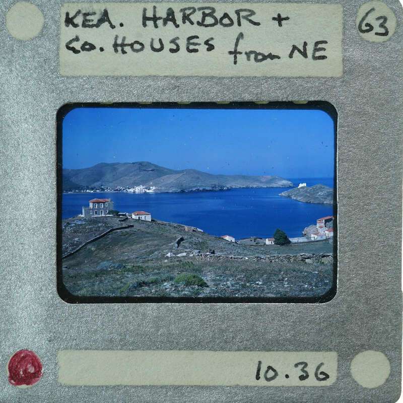 A vintage film strip with a photograph of a coastal landscape featuring houses and the sea.