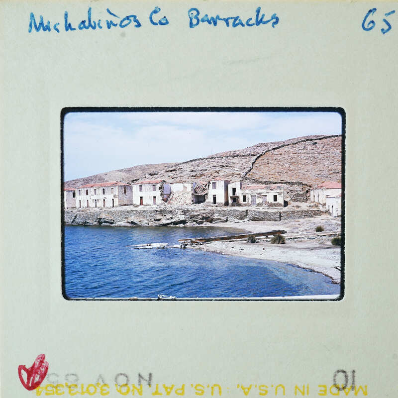 An old village by the sea with dilapidated buildings, on a postcard.