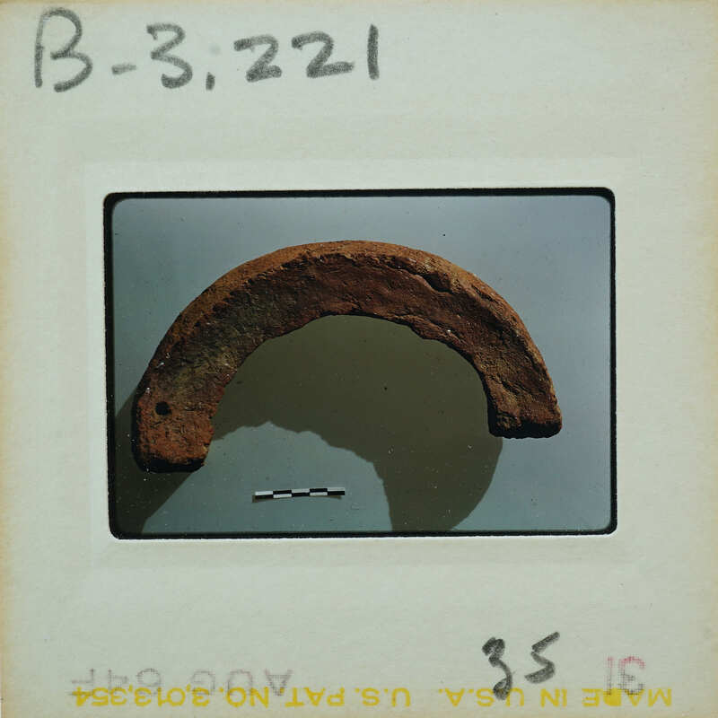 A rusted metal object on display, possibly an artifact or a piece of history.