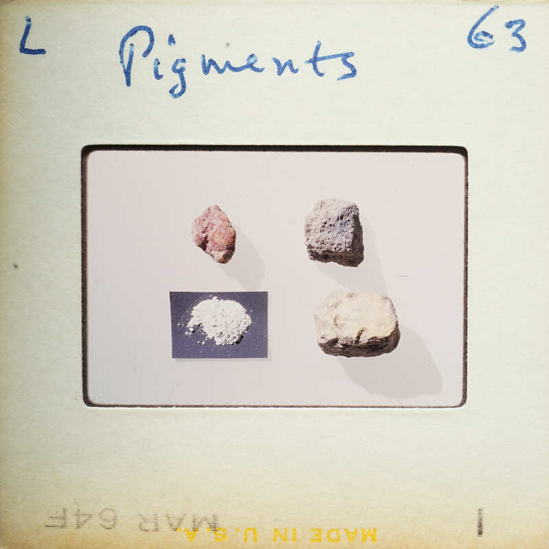 A photograph of four different colored pigments on a white surface, with labels and numbers.