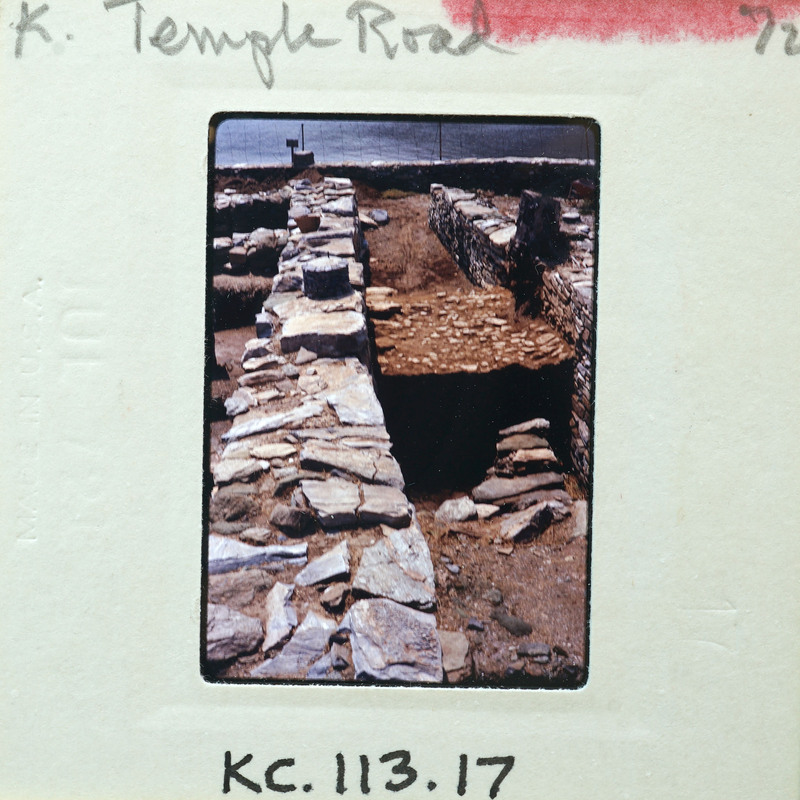 A photograph of a stone structure with visible layers and ruins.