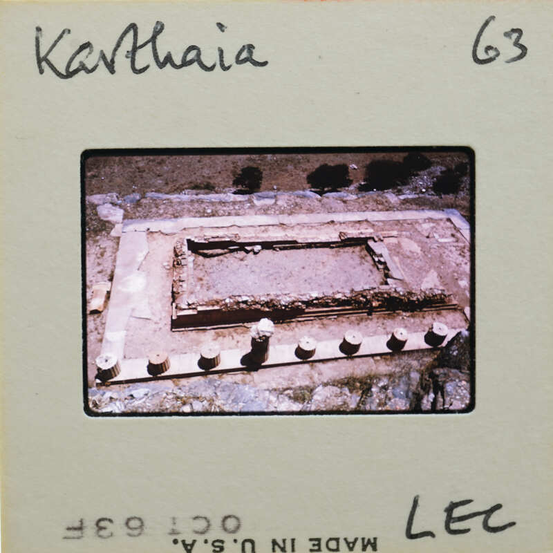 A slide of a weathered stone structure with column remains around the edges.