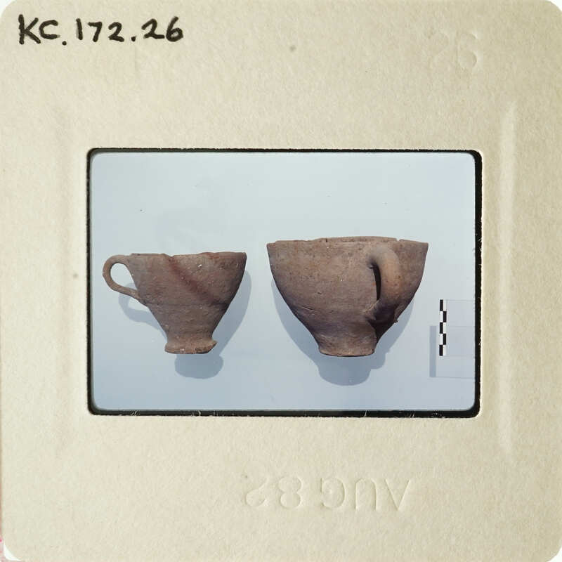 Two ancient pottery cups on display.