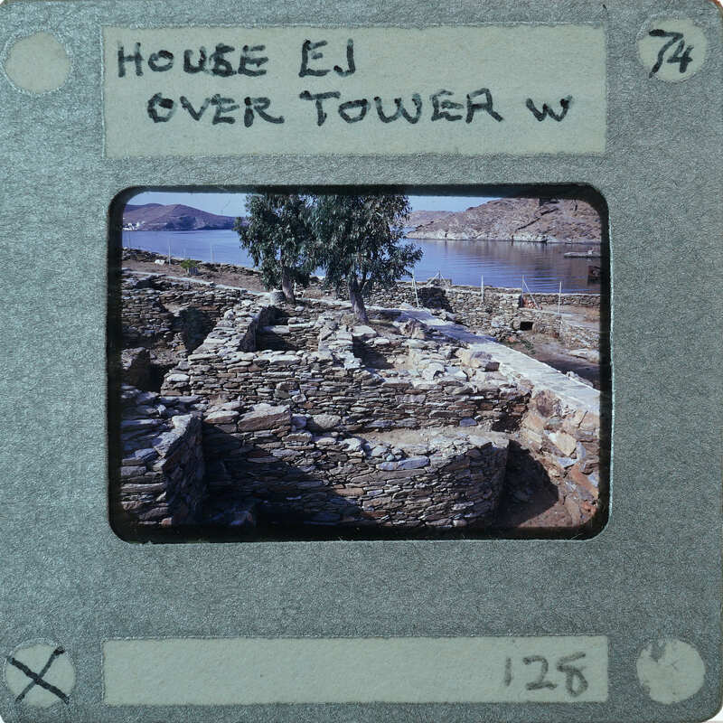 An old, stone-built structure with a tree near it, photographed on a vintage film format.
