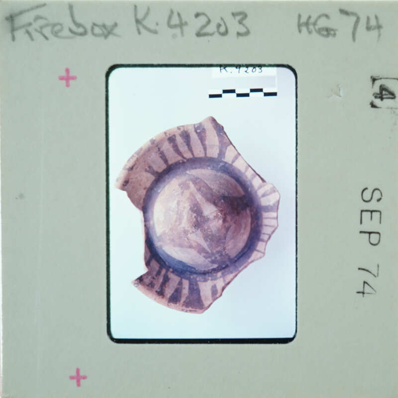 A small, round object with a pattern on it, photographed and placed on a film strip.