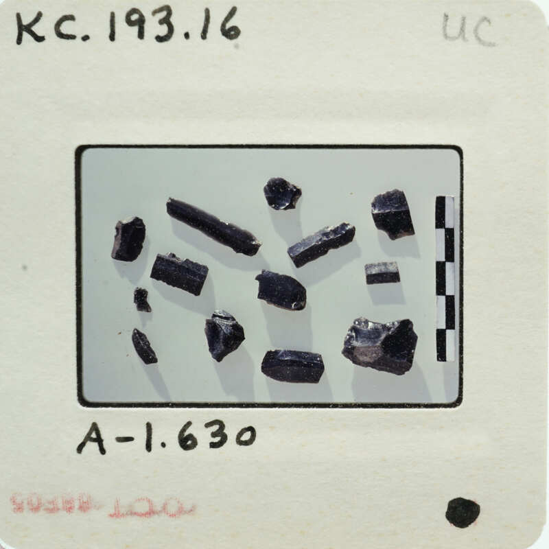 Photograph of a collection of stone items with labels and measurements on a white background.