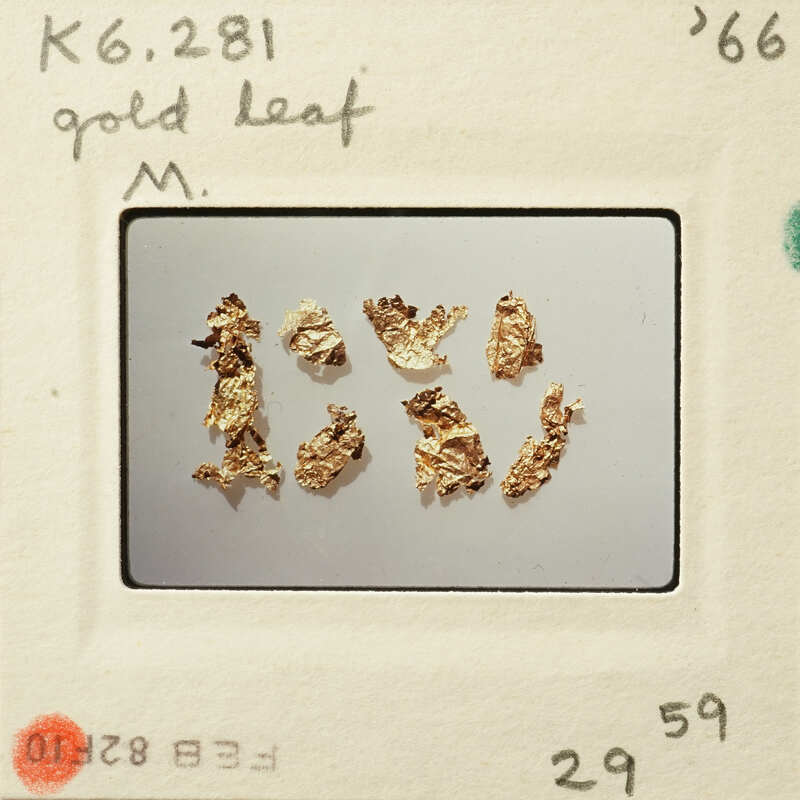 Gold leaf samples displayed on a white surface.