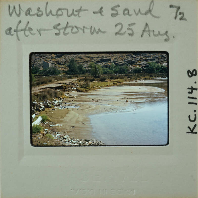 A photograph of a dried-up riverbed with sand and rocks, labeled "Washed Out & Sanded 25 Aug".