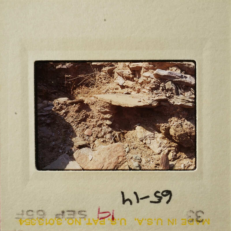 Rocky terrain with exposed layers and debris, possibly from erosion.