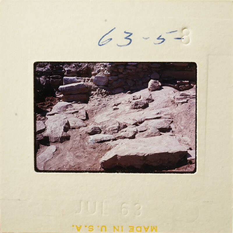 A photograph of an ancient archaeological site with stone ruins and rocks.