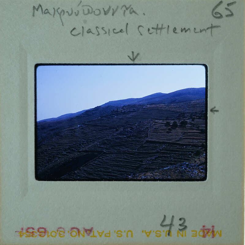 A photograph of a mountainous landscape with agricultural terraces and annotations on the border.